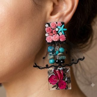 Handmade statement earrings featuring preserved pink hydrangea flowers, natural black moss, genuine apatite crystal beads, black tulle, crystal resin, and sparkling rhinestones in an artistic botanical design.
